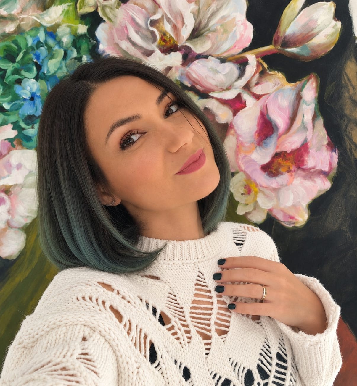 Mirela Patras in front of one of her flower paintings